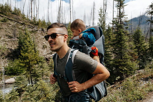 Young father hiking with toddler in mountains photo