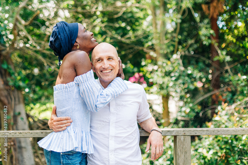Happy diverse couple standing in embrace on terrace Happy diverse couple standing in embrace on terrace