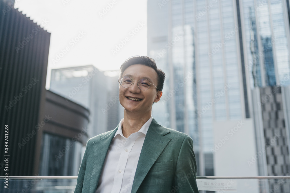 Man smiling in front of city buildings Man smiling in front of city buildings