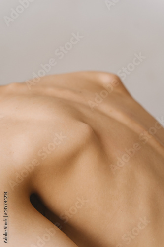 Nude female back with protruding shoulder blades photo