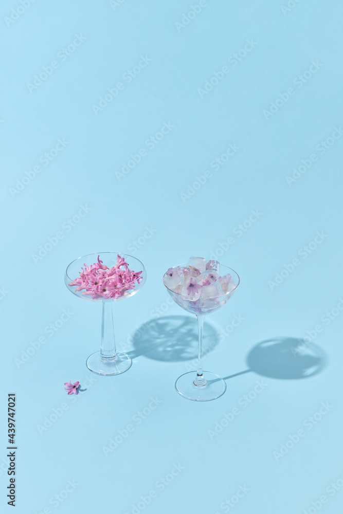 Small flowers and ice cubes in glasses Small flowers and ice cubes in glasses