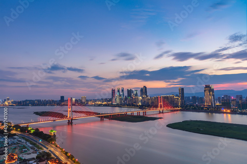 Stunning city skyline, full of sunset and rosy clouds, just like a dream. Above the Ganjiang River, the bridge passes through. Nanchang, China.
