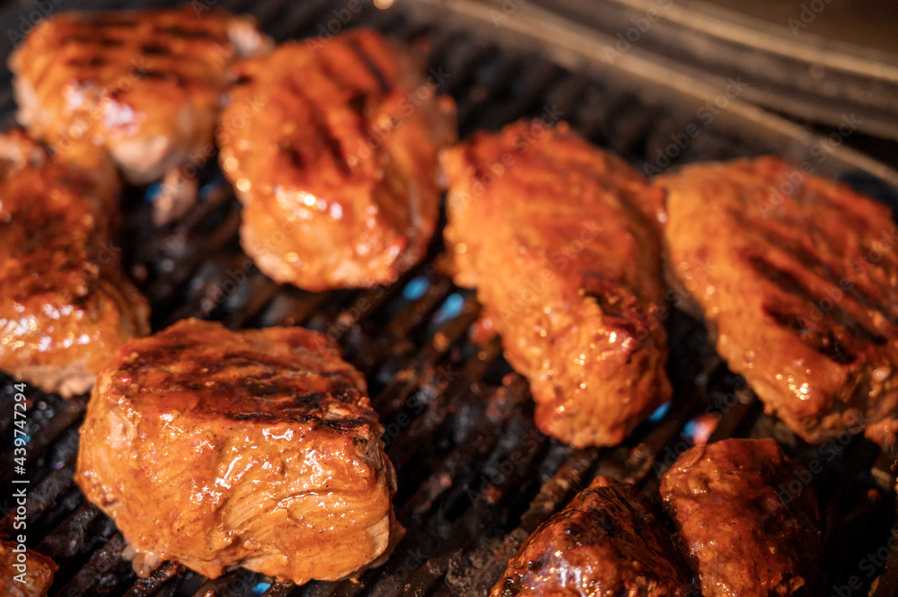 Steaks grilling on a gas barbecue covered in spicy BBQ sauce. Steaks grilling on a gas barbecue covered in spicy BBQ sauce.