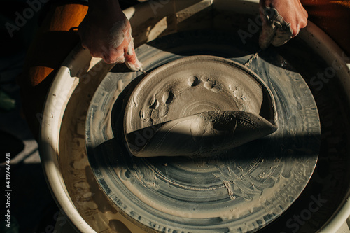 Potter taking clay from the pottery wheel