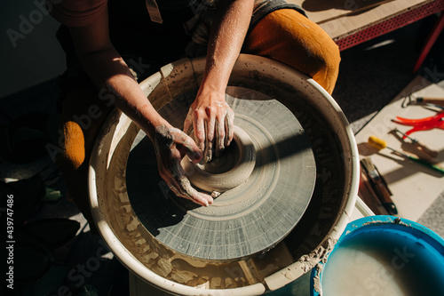 Ceramic artist working on the pottery wheel photo