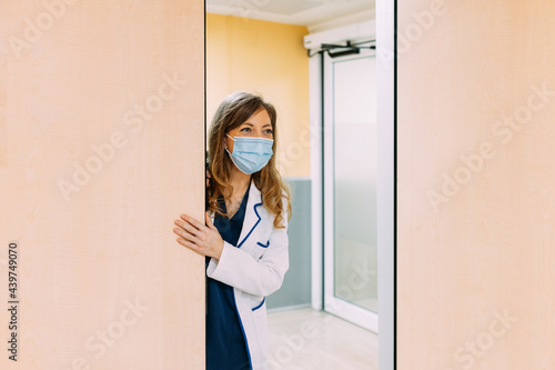 Real nurse in white uniform and white coat in hospital corridor photo