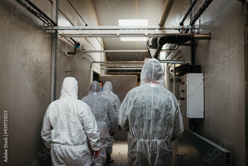 People wearing protective clothing walking away in a building