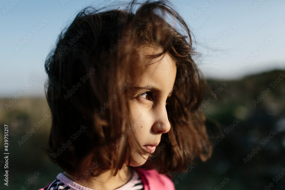 Close up of kid in sunlight with fluttering hair Close up of kid in sunlight with fluttering hair