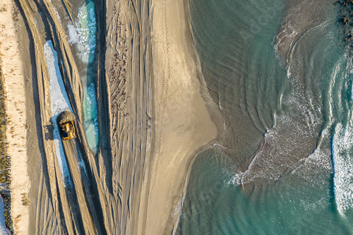 Aerial view of a Bulldozer moving sand on the beach photo