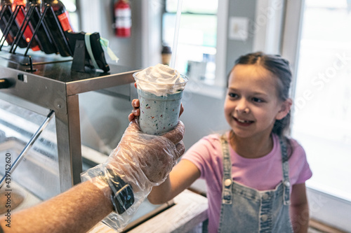 Young Girl Handed A Milkshake photo