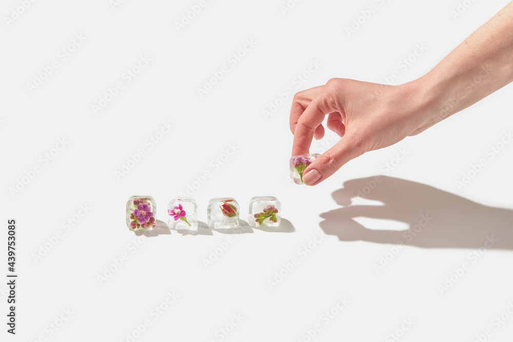 Woman holding ice cube with flower Woman holding ice cube with flower