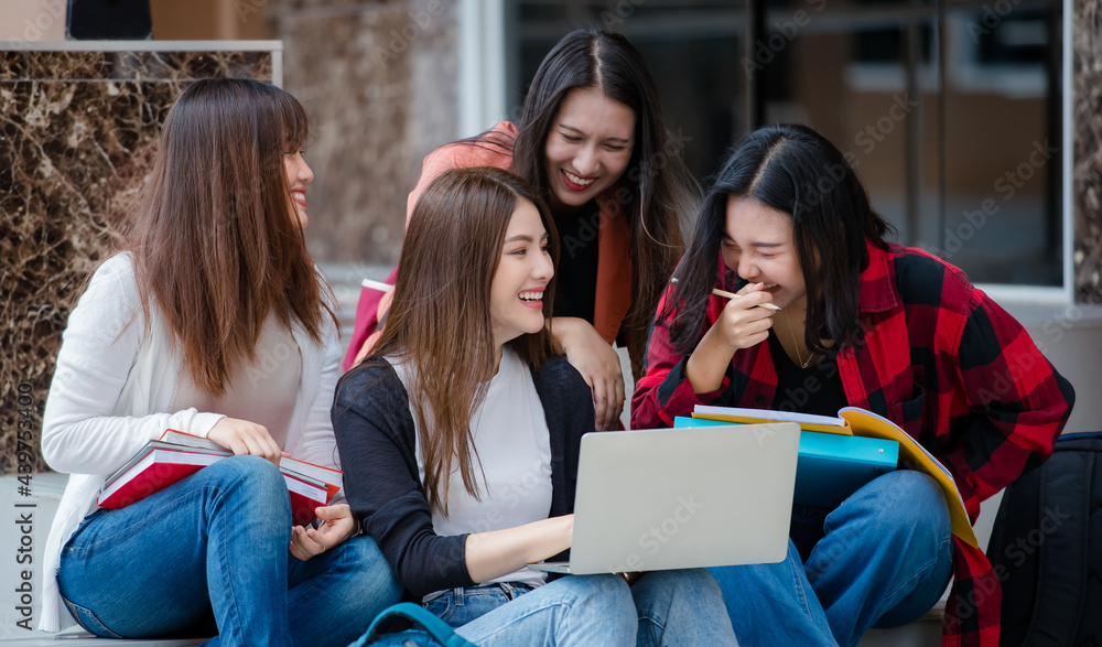 Group of four young attractive asian girls college students studying together using laptop in university campus outdoor. Concept for education, friendship and college students life Group of four young attractive asian girls college students studying together using laptop in university campus outdoor. Concept for education, friendship and college students life