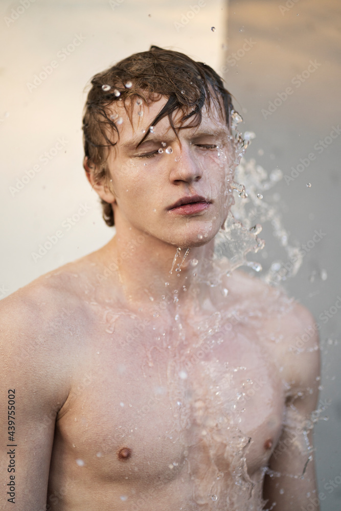 Calm man under plash of water Calm man under plash of water