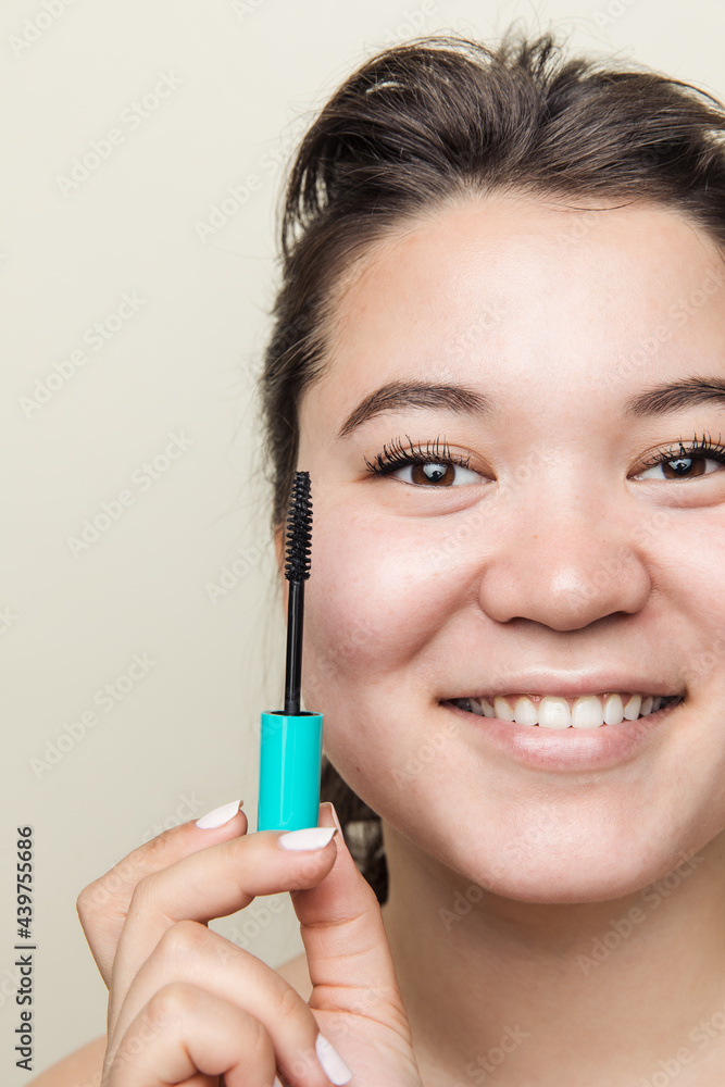 Young happy eastern asian woman holding mascara brush Young happy eastern asian woman holding mascara brush