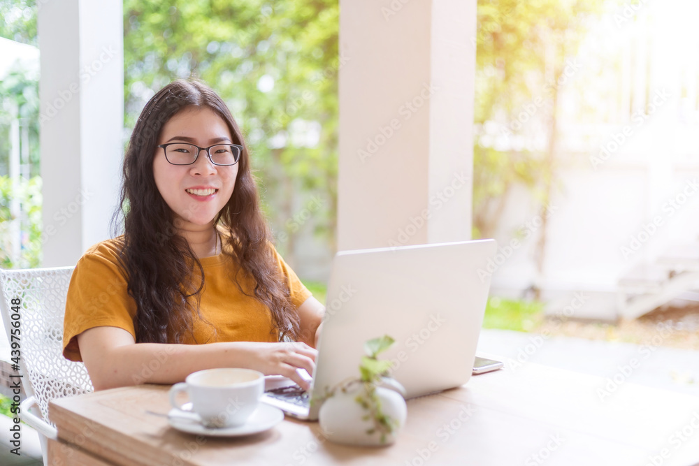 Happy of asian freelance people business female casual working with laptop computer with coffee cup and smartphone in coffee shop like the background,communication concept