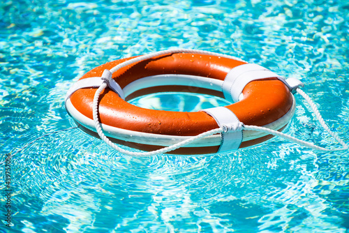 Drowning in water catch lifebuoy. Safety and urgent help. Resque needed. Life buoy floating in pool. photo