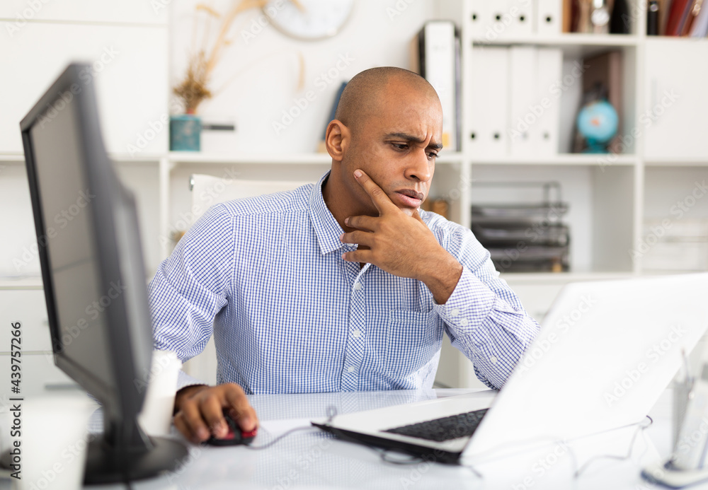 Naklejka premium Frustrated tired office manager working at laptop