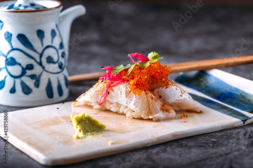 Tasty sushi with fish and tobiko on table photo