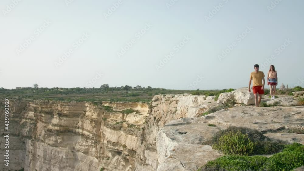 Couple hiking near the edge of a cliff on the island of Gozo, Malta. Couple hiking near the edge of a cliff on the island of Gozo, Malta.