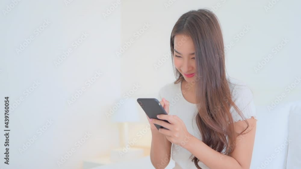 Cheerful beautiful Asian woman chatting on smartphone with white background for copy space Cheerful beautiful Asian woman chatting on smartphone with white background for copy space