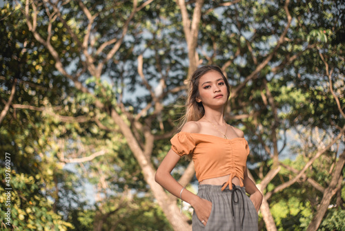 A young, thin and fashionable asian woman posing outdoors. photo