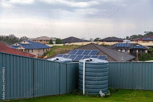 Incoming rain storm over rooftops in town and rainwater tank in backyard photo