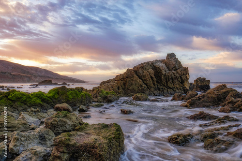 Dramatic sunrise at Leo Carrillo Beach with large rock formation. photo