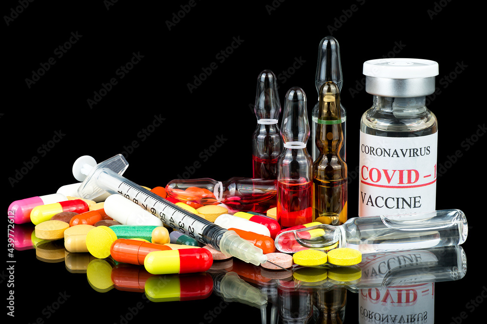 Syringe with glass vials and medicinal tablets and pills on black background. Assorted medical drugs. Syringe with glass vials and medicinal tablets and pills on black background. Assorted medical drugs.