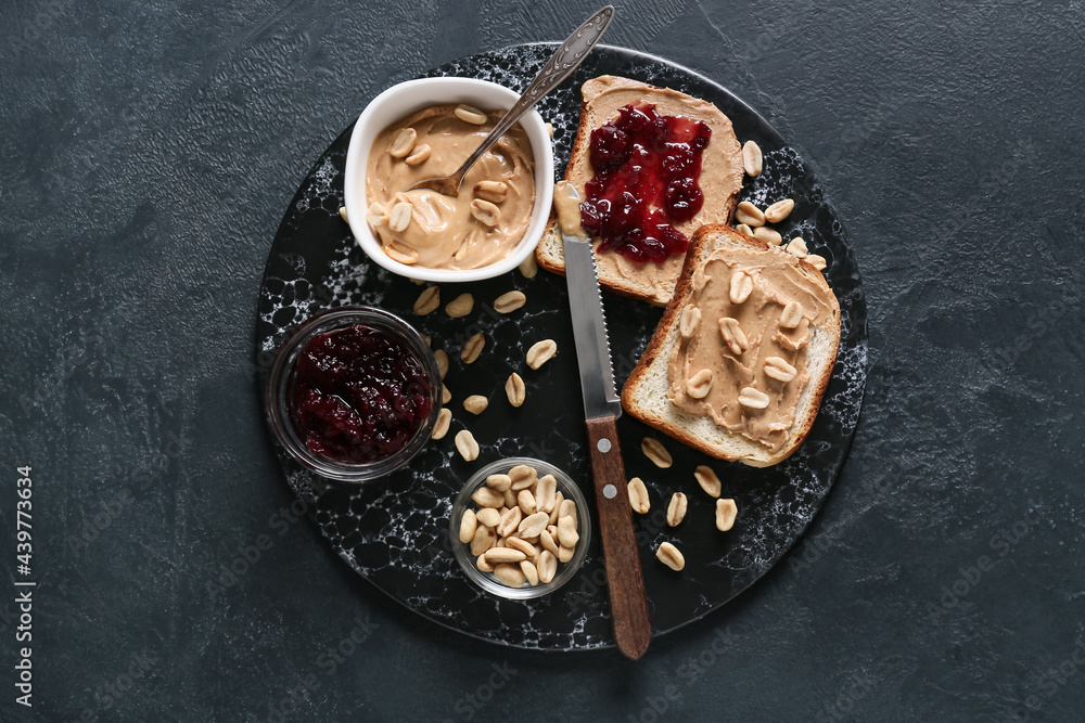 Bread with tasty peanut butter and jam on dark background Bread with tasty peanut butter and jam on dark background
