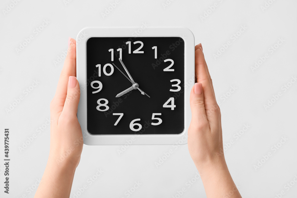 Female hands with stylish clock on light background, closeup Female hands with stylish clock on light background, closeup