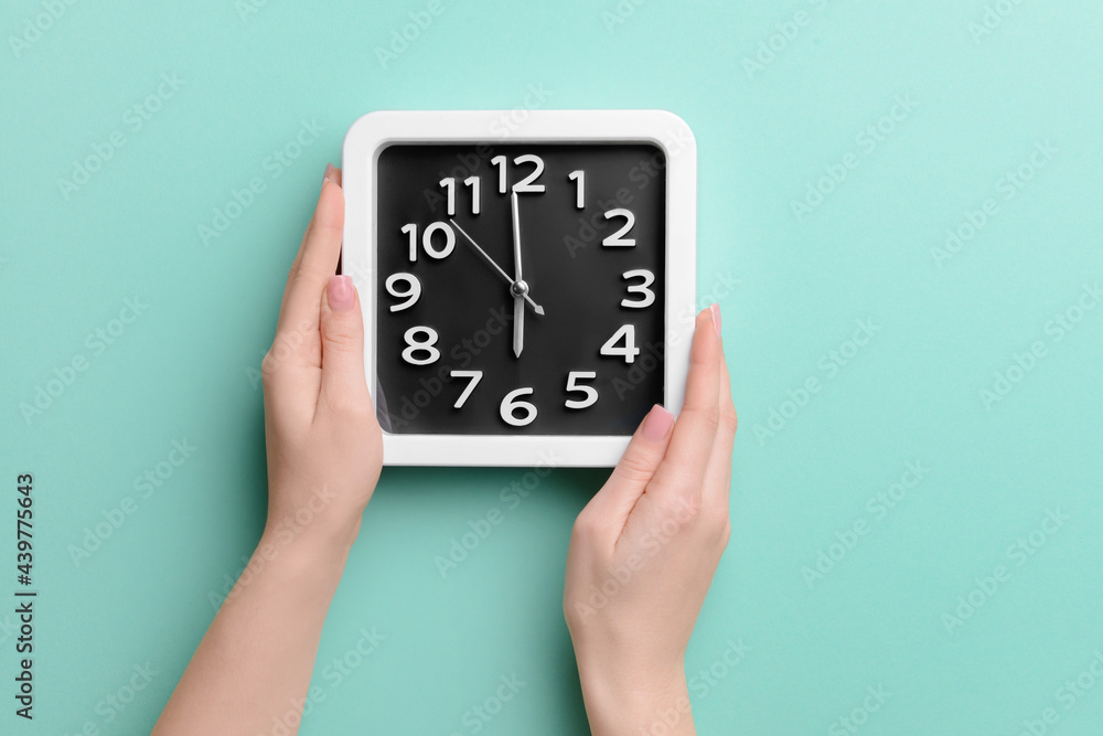 Female hands with stylish clock on color background, closeup Female hands with stylish clock on color background, closeup