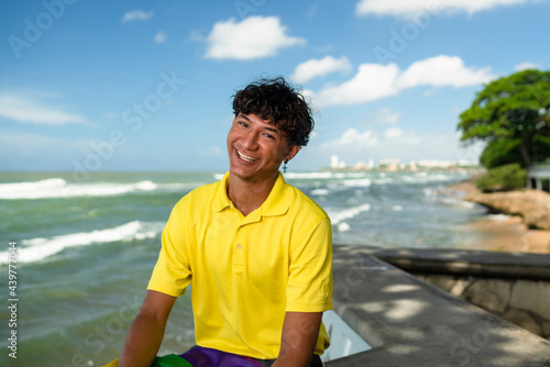 Young gay man proudly holding the lgbt flag in his hands