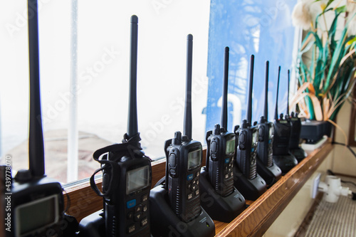 Many walkie-talkies stand in the chargers and charge.