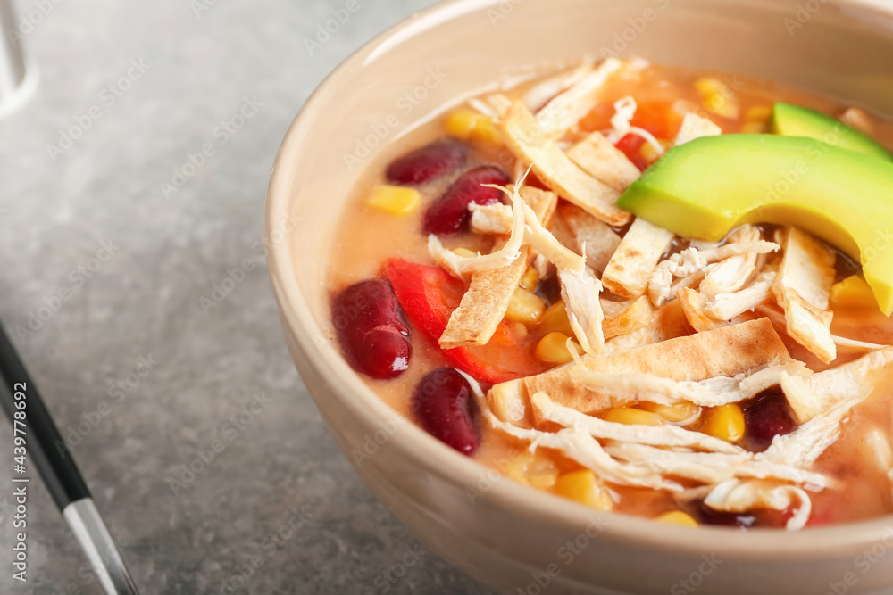 Bowl of tasty chicken enchilada soup on table, closeup Bowl of tasty chicken enchilada soup on table, closeup