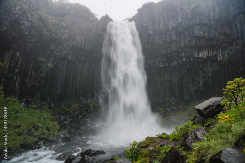 Svartifoss waterfall on moody, foggy, misty weather. Popular tourist attraction scene. Location Skaftafell National Park, Vatnajokull glacier, Iceland, Europe. Beauty of earth.