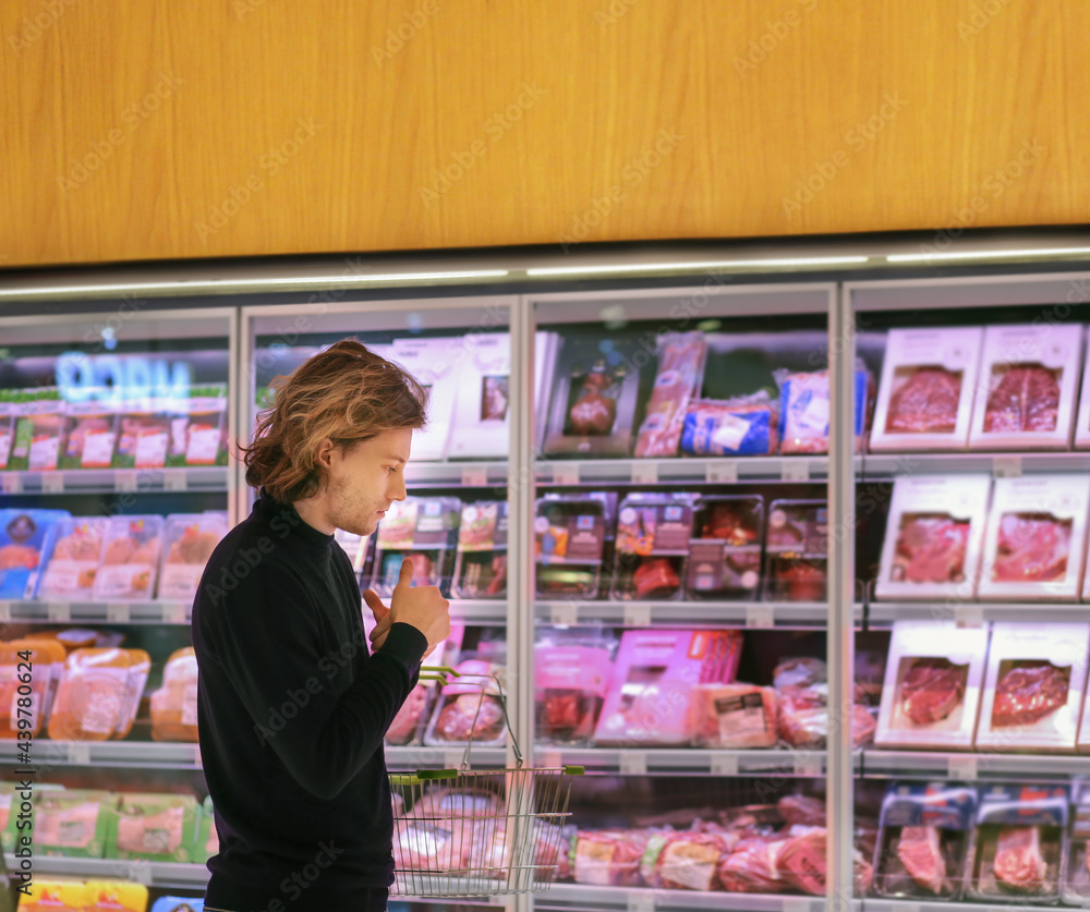 man purchasing a packet of meat at the supermarket.
