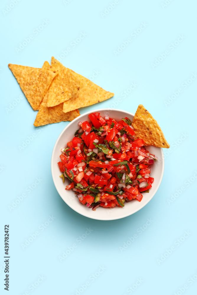 Bowl of tasty Pico de Gallo salsa and nachos on color background Bowl of tasty Pico de Gallo salsa and nachos on color background