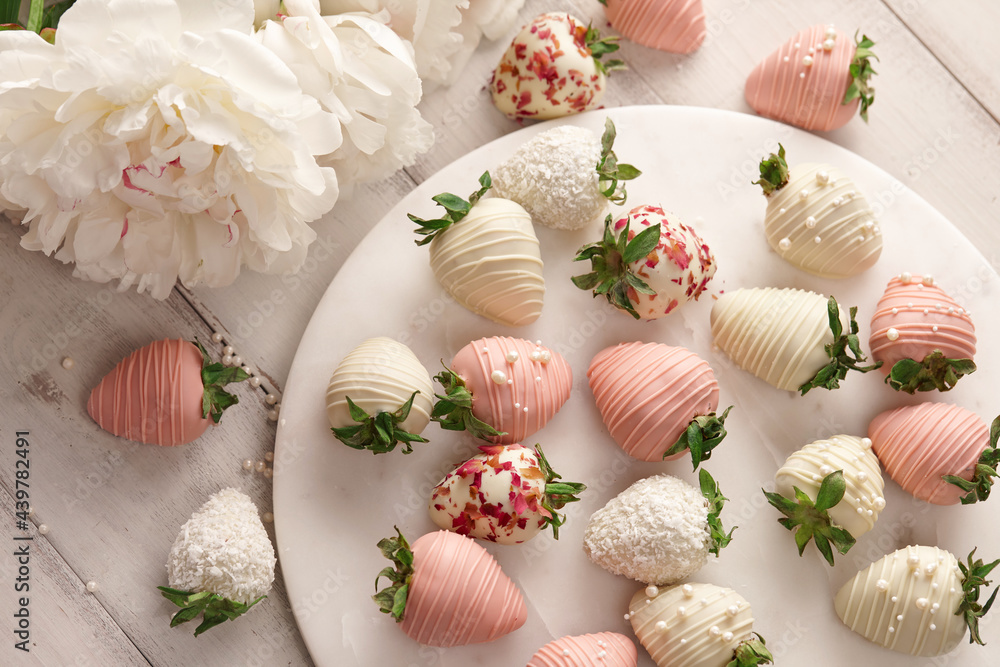 White and pink chocolate dipped strawberries on white table