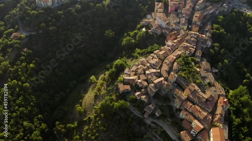 Scansano town from above. Aerial beautiful stunning view. Geometrical streets and roads. Tiled roofs and trees on the hills. Small city in Tuscany, Italy. View from drone. Tourism concept.  photo