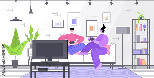 couple having fun playing video games man woman using wireless gamepads controllers game e-sports leisure gaming