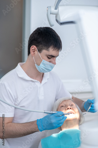 Male dentist working with a senior patient with periodental disease photo