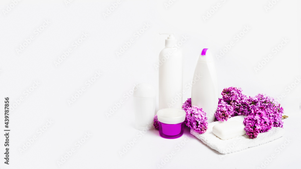 organic body care products and space for text on white background with lilac flowers. Cosmetic products, toiletries for hygiene.
