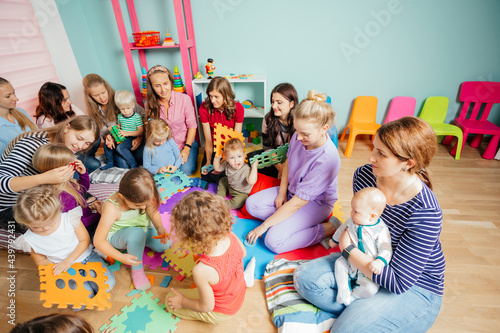 Mothers with children of different ages gathered together photo