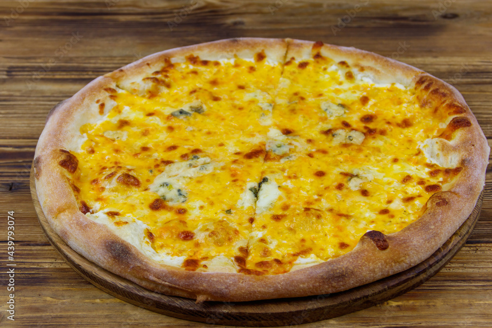 Pizza Four cheese on a wooden background Pizza Four cheese on a wooden background
