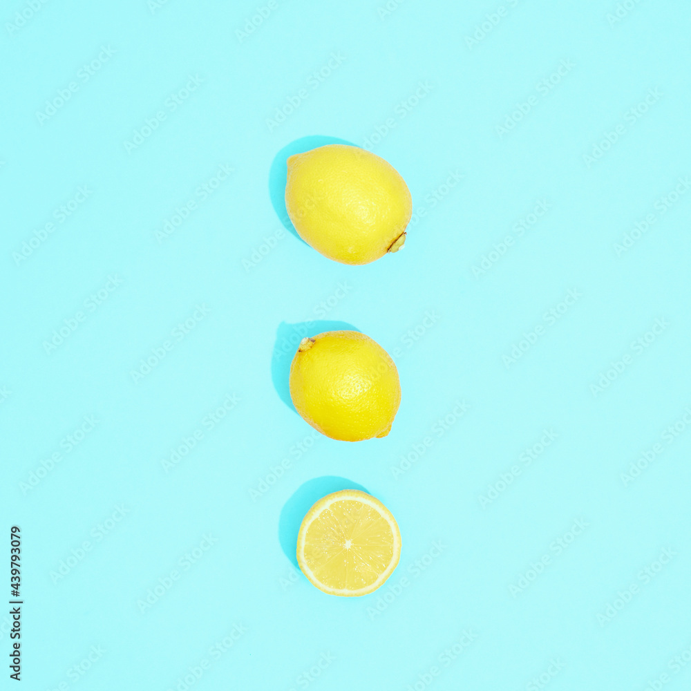Composition with lemons on blue background, top view.