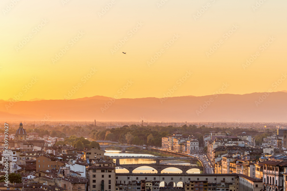 Sunset view of Florence in Italy with a airliner that lifts
