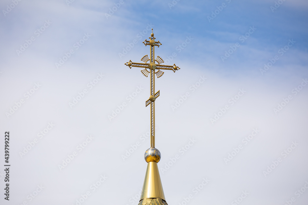 The golden dome and the cross of the Orthodox church against the blue sky and clouds. The golden dome and the cross of the Orthodox church against the blue sky and clouds.