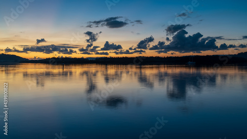 Blue hour bay waterscape with scattered clouds