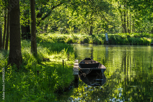 Water canal with old boat in the biosphere reserve Spree forest (Spreewald) in the state of Brandenburg, Germany, in springtime.