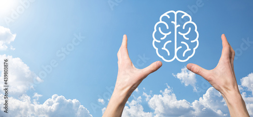 Male hand holding brain icon on blue background. Artificial intelligence Machine Learning Business Internet Technology Concept.Banner with copy space